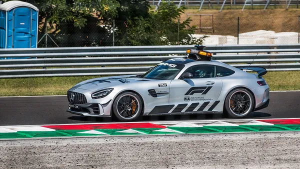 Paddock de Fórmula 1 com mecânicos preparando carro antes da corrida