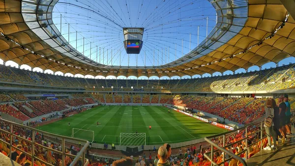Estádio iluminado durante final europeia com público lotando arquibancadas