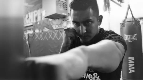 Lutador de MMA acerta golpe durante treino simulando luta no octógono