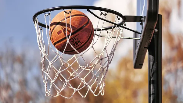 Bola de basquete entrando na cesta em jogo da NBA
