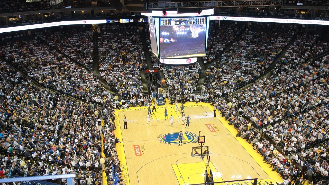 Quadra de basquete iluminada vista do alto durante jogo de playoffs