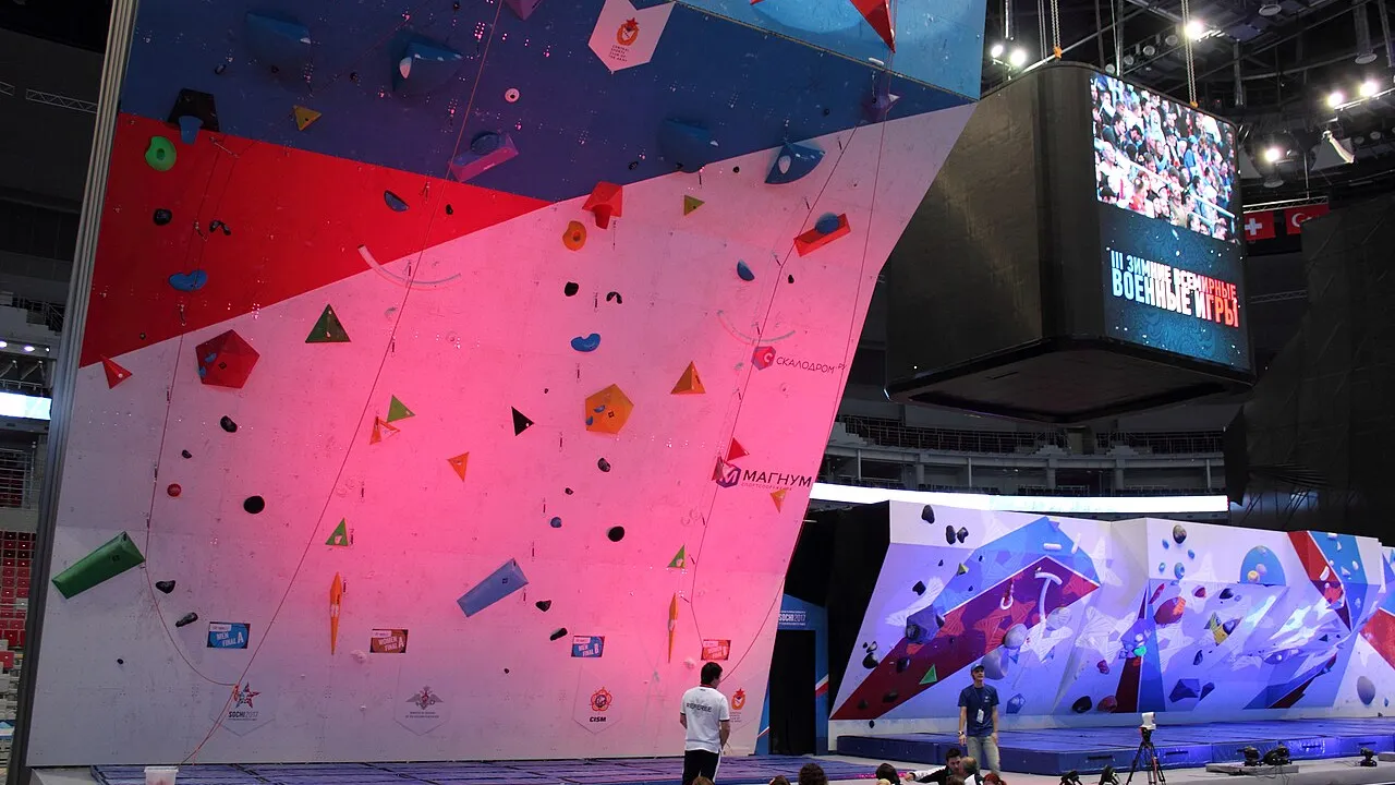 Atleta de escalada esportiva em parede de lead durante competição internacional