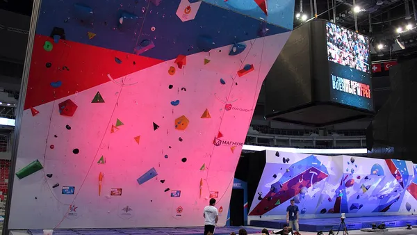 Atleta de escalada esportiva em parede de lead durante competição internacional