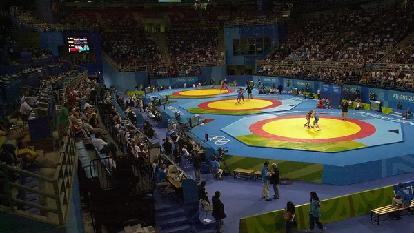 Atletas em luta de wrestling sobre tatame oficial em competição internacional