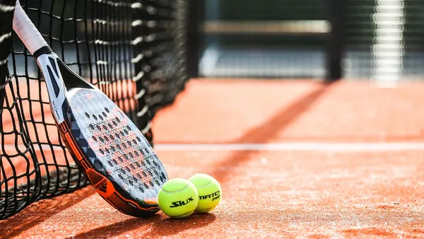 Tenista feminina executando backhand em quadra de saibro