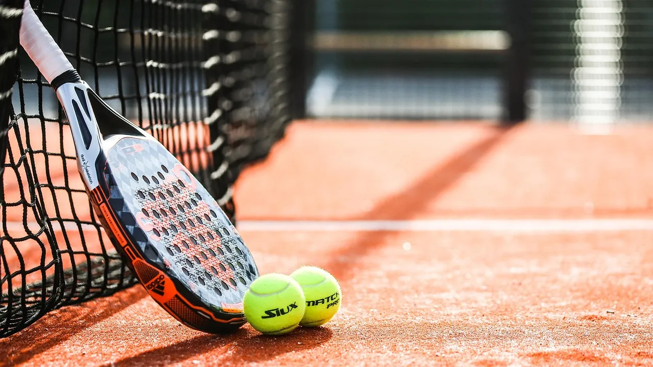 Tenista feminina executando backhand em quadra de saibro