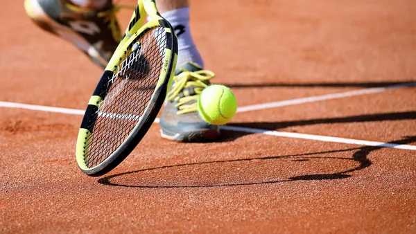 Bola e raquete sobre quadra de saibro, ilustrando o WTA 1000 de Roma 2026